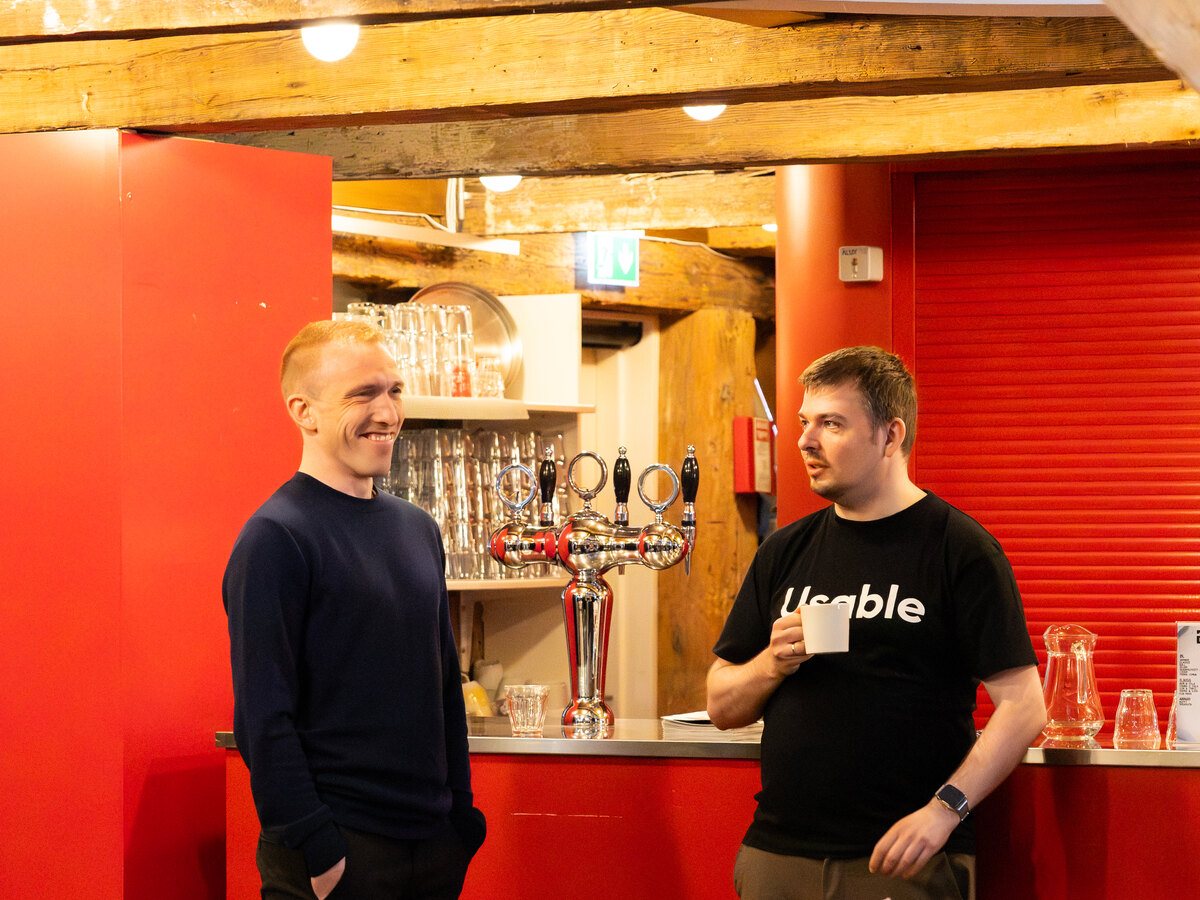 Participants speaking near the bar at Reinsaríið during Usable Fragments 2026